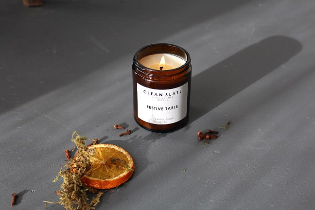 Festive Table Orange + Clove  Amber Candle alight.