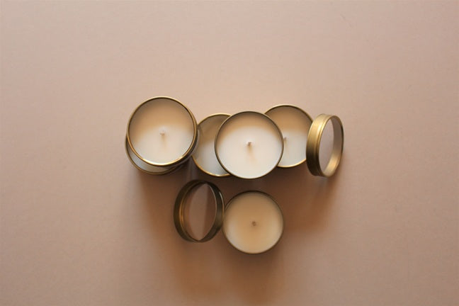 Gold Tin Scented Candles fstacked on top of each other.