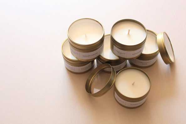 Gold Tin Scented Candles fstacked on top of each other.