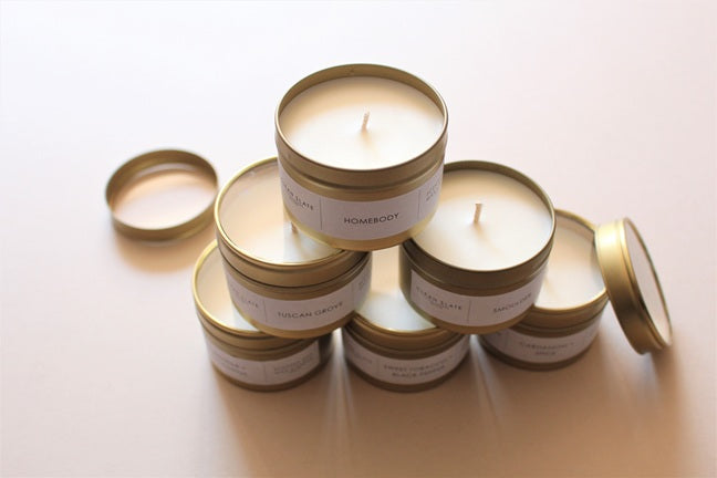 Gold Tin Scented Candles fstacked on top of each other.