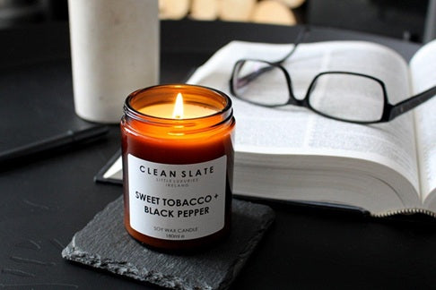 Sweet Tobacco + Black Pepper Amber Candle alight.
