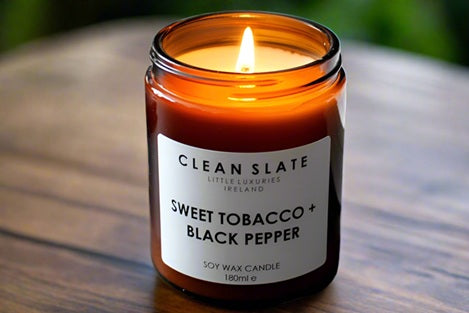 Sweet Tobacco + Black Pepper Amber Candle alight.