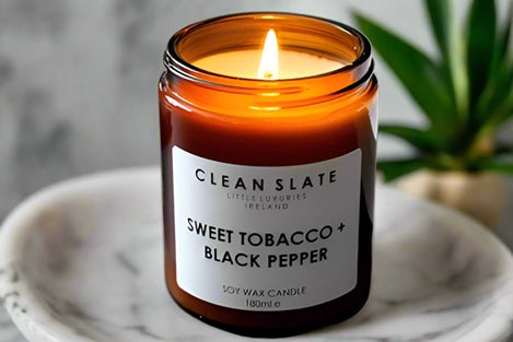 Sweet Tobacco + Black Pepper Amber Candle alight.