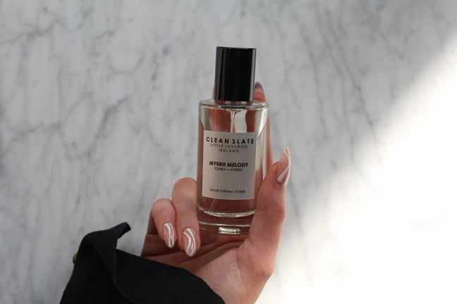 Myrrh Melody Eau De Parfum 50ML bottle held in a woman's hand.