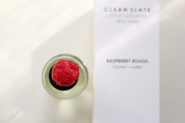 Close-up Raspberry Rouge Eau De Parfum 50ML bottle with raspberry on top and box.