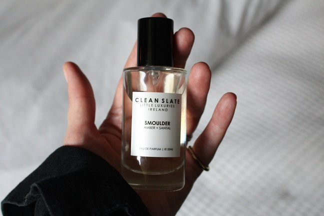 Close-up of Smoulder Eau De Parfum 50ML bottle in a woman's hand.